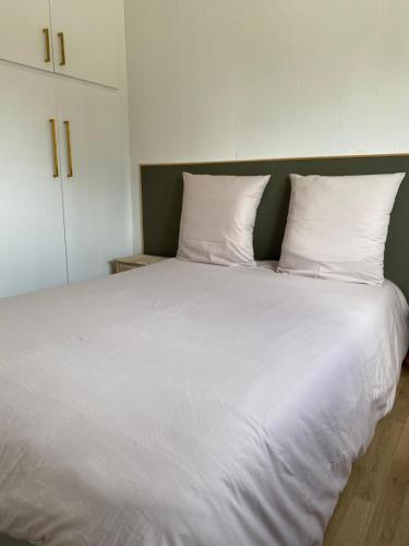 博尼法乔Petit chalet d’été avec piscine privée chauffée的一张配有白色床单和枕头的大床