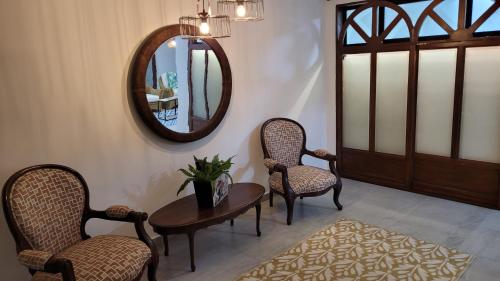 布卡拉曼加Casa 59 - Guest House的一间设有两把椅子、一张桌子和一面镜子的房间