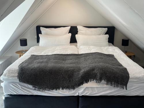 施塔德Altstadtlage 4的一张黑白的床上,上面有黑色的毯子