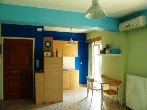 雷夫卡达镇Casa di Maura的厨房拥有蓝色的墙壁,配有桌椅