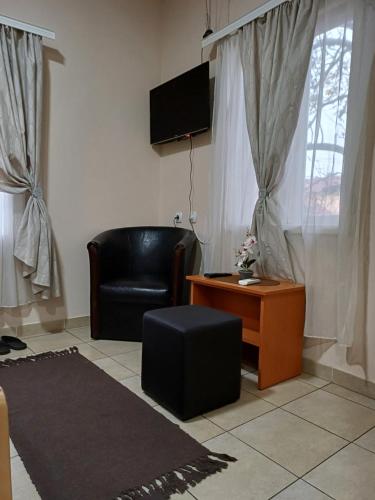 皮罗特Sobe SANjA的客厅配有黑色真皮座椅和桌子