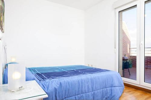 滨海罗克塔斯Apartment Brisa Marina的窗户客房内的一张蓝色的床