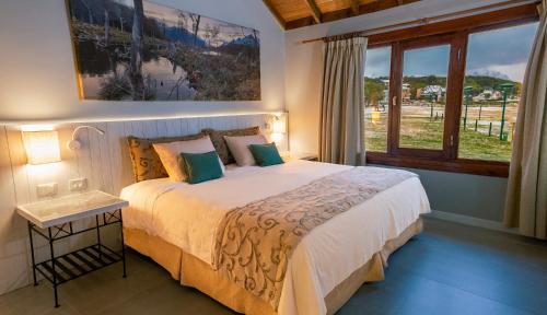 乌斯怀亚Tolkeyen Ushuaia Hotel的一间卧室设有一张大床和一个窗户。