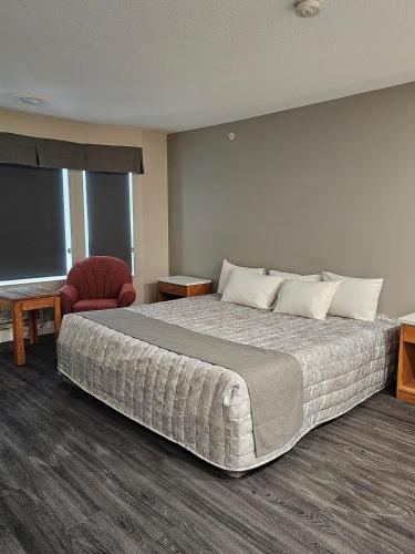 勒杜克Western Budget Motel #1 Leduc/Nisku的酒店客房带一张大床和一把椅子