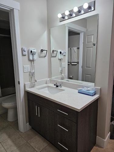 勒杜克Western Budget Motel #1 Leduc/Nisku的一间带水槽和大镜子的浴室