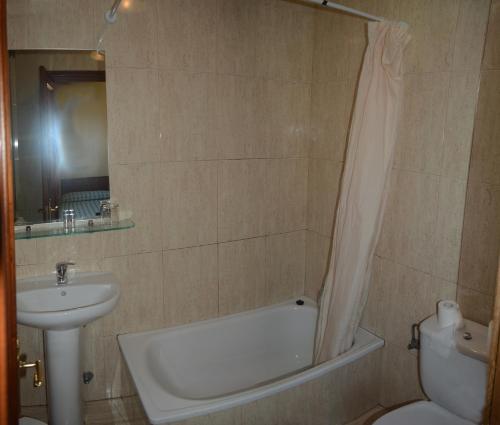 Pesués巴伐利亚旅馆的一间带水槽、浴缸和卫生间的浴室