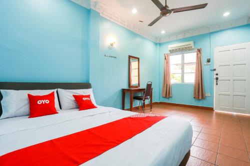班吉OYO 44094 Bangi Lanai Hotel的一间拥有蓝色墙壁的卧室和一张带红色枕头的床