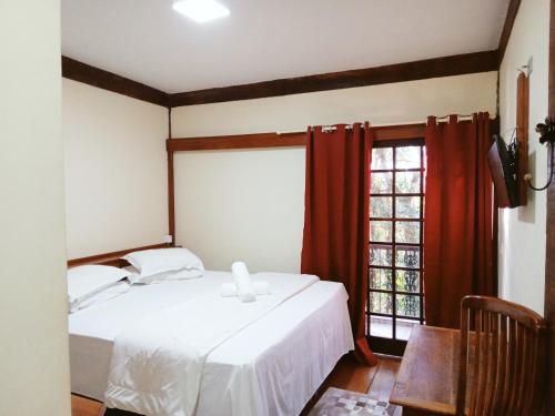 圣安东尼奥-杜皮尼亚尔Pousada Le Lieu的卧室配有白色的床和窗户。