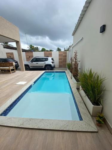 盖比姆Guaibim House- Sua casa de praia的院子里的蓝色游泳池,有车