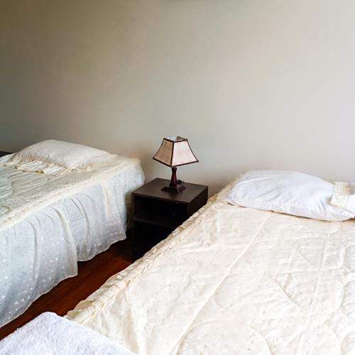 奇瓦伊Apartamento Colca 's Home, cuenta con dos habitaciones的卧室内的两张床,在床头柜上配有一盏灯
