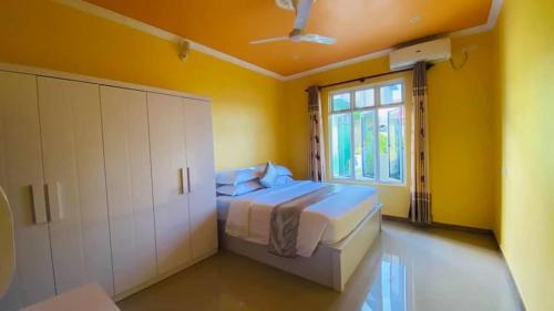 呼拉Maavaharu - K.Huraa的黄色的卧室设有床和窗户