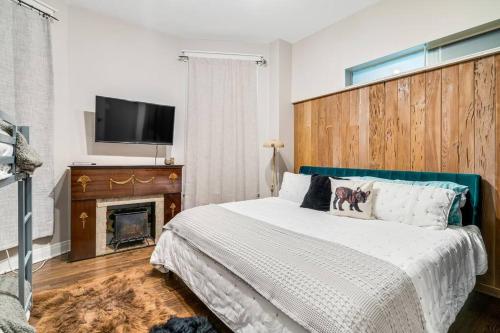 芝加哥The Village Inn by Dakota Gal Digs的一间卧室配有一张带壁炉和平面电视的床。