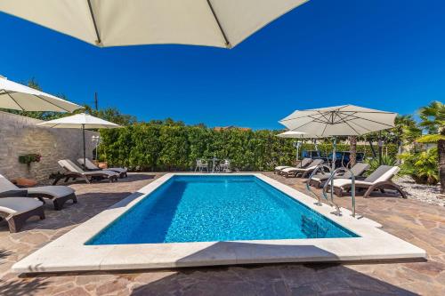 马林斯卡Guest House Antonella的游泳池旁设有椅子和遮阳伞