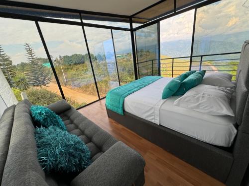 LebrijaSe Alquila Hermosa Cabaña Turquesa的卧室配有一张床,窗户前配有一张沙发