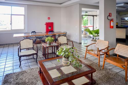 里奥韦尔迪Honorato Hotel的客厅配有椅子和桌子