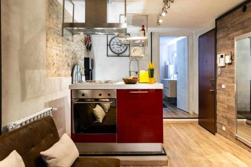 布雷西亚La Casa dello Stilista的一间带炉灶和红色橱柜的厨房