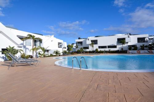 拉哈雷斯Luxury Apartment in Casilla de Costa - Casa MEVA的一座游泳池位于一些白色建筑前