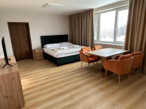 科希策Apartmány Loky的配有一张床和一张桌子及椅子的房间