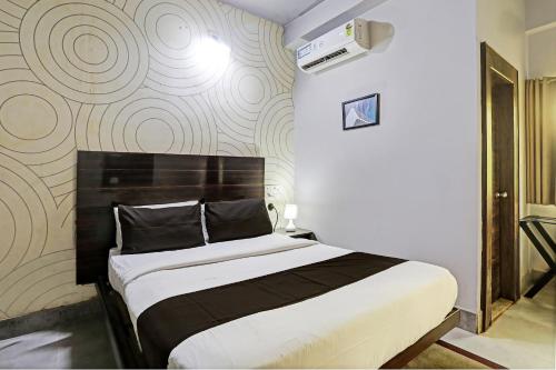 布巴内什瓦尔Super Collection O Hotel Bhinna Sakala的一间卧室设有一张床和一面墙