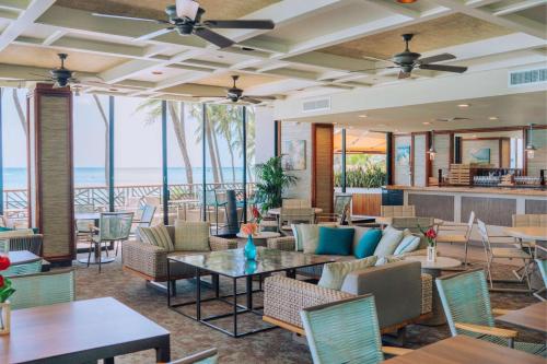 檀香山OUTRIGGER Waikiki Beach Resort的大堂设有桌椅和海滩。