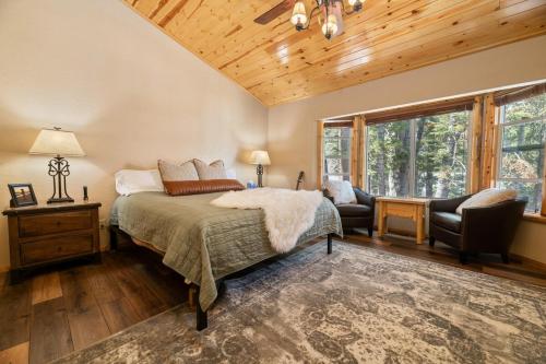大熊湖Big Bear Family Chateau, Hot Tub, Pool Table, Ev的卧室配有床、椅子和窗户。