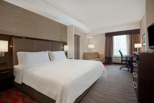 巴里巴里智选假日套房酒店的酒店客房设有一张大床和一张书桌。