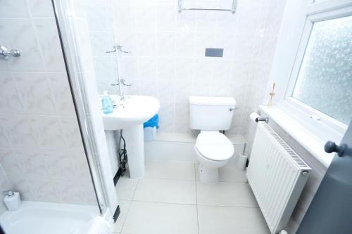 霍利Acorn Lodge Hotel Gatwick & Parking的白色的浴室设有卫生间和水槽。