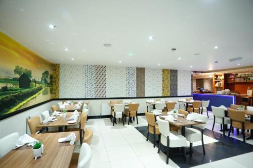 霍利Acorn Lodge Hotel Gatwick & Parking的餐厅内带桌椅的用餐室