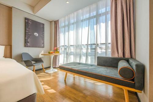 广州广州白云山机场路亚朵X酒店的卧室在窗户前配有沙发