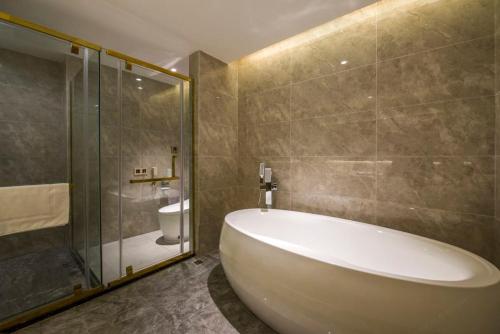 广州广州白云山机场路亚朵X酒店的带浴缸、淋浴和卫生间的浴室
