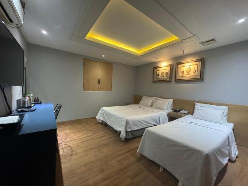 首尔Urban Nest Hotel的一间酒店客房,设有两张床和电视