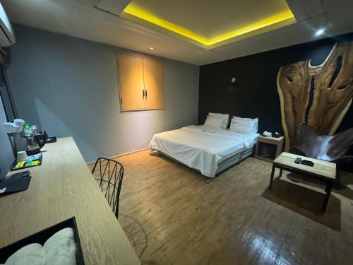 首尔Urban Nest Hotel的酒店客房设有一张床铺、一张桌子和一张桌子。