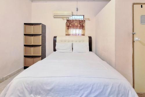 DukuHandira Homestay Syariah Padang RedPartner的卧室配有白色的床
