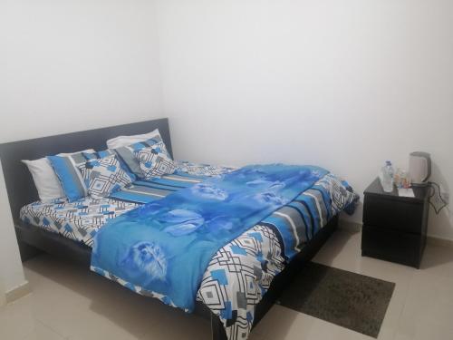 阿布扎比ETAS Residence的一张带蓝色和白色床单及枕头的床