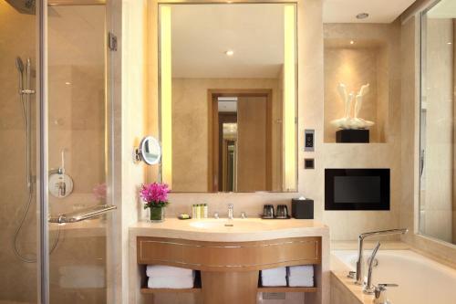 广州广州希尔顿逸林酒店-免费往返广交会穿梭巴士&参展商办证点的一间带水槽、浴缸和镜子的浴室
