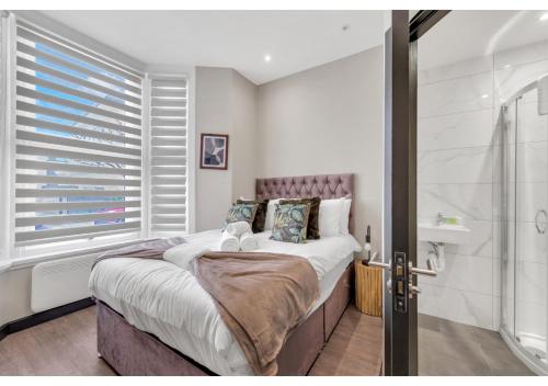 伦敦Escape the Ordinary: Cozy and Charming Studio的一间卧室设有一张大床和淋浴