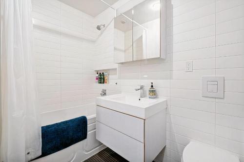 温哥华Modern, Bright & Beautiful, 1 Bedroom Downtown Apt with Rooftop Patio的白色的浴室设有水槽和浴缸。