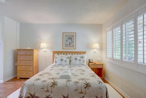 TequestaTequesta Palms Inn的一间卧室设有一张床和两个窗户。