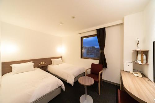 山口Business Hotel Ueno的酒店客房设有两张床和窗户。