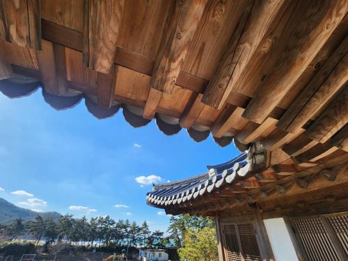 泰安Hotelarrive Taean Tiann HanokBeachResort的一座建筑的屋顶,背景是蓝色的天空