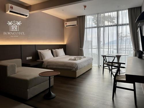 哥打京那巴鲁Borneotel The Shore KK by CHG的酒店客房,设有两张床和一张沙发