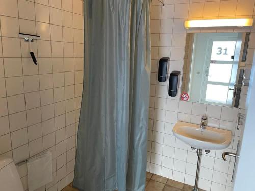 维堡维伯格汽车旅馆的一间带水槽和淋浴帘的浴室