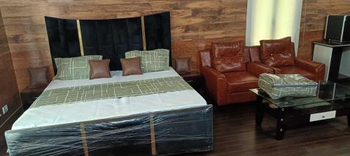 贾姆穆Homewood Suites And Guest House的一间卧室配有一张床和两把椅子