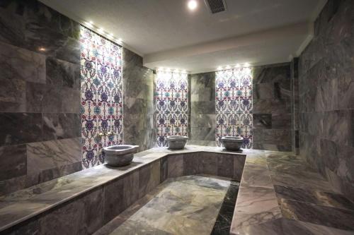 加济安泰普乌古鲁酒店的浴室设有3个水槽和彩色玻璃窗。