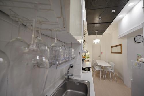 首尔Soo Guest House的厨房配有水槽和带玻璃杯的台面。