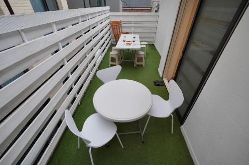 首尔Soo Guest House的小阳台配有白色的桌椅