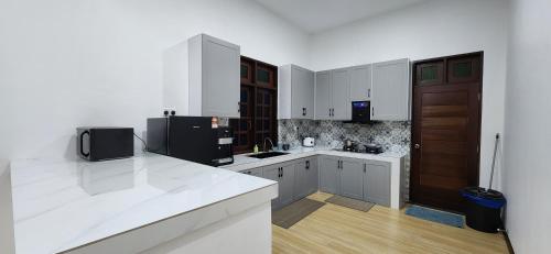 士兆Najazi Villa的厨房配有白色橱柜和黑色冰箱。