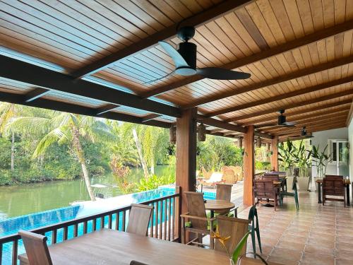 象岛Nanai Resort Salakphet的天井上配有带桌椅的木制凉亭