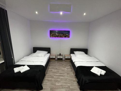 盖尔森基兴Wellness Suite mit Whirlpool und Sauna的紫色天花板客房的两张床