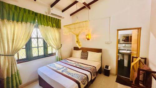 丹不拉新孔雀度假酒店的一间卧室设有一张床和一个窗口